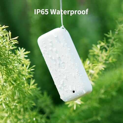 White waterproof device with droplets hanging among green plants.